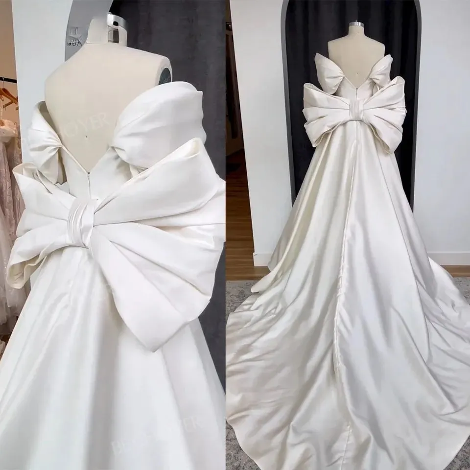 Ellegant off shoulder wedding dress. Satin bow back bridal gown.