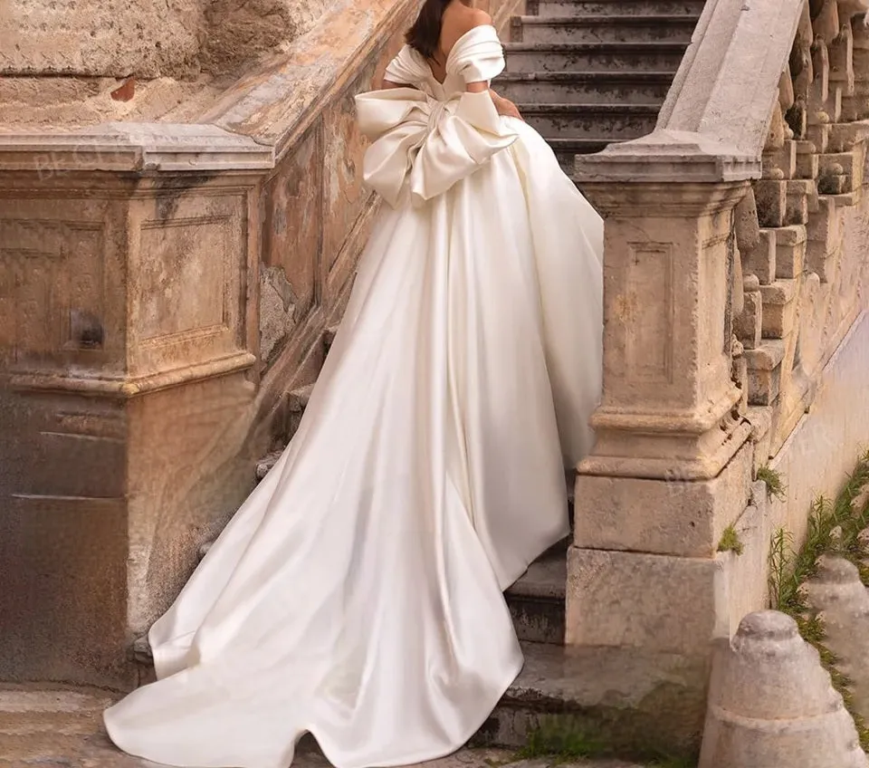 Ellegant off shoulder wedding dress. Satin bow back bridal gown.