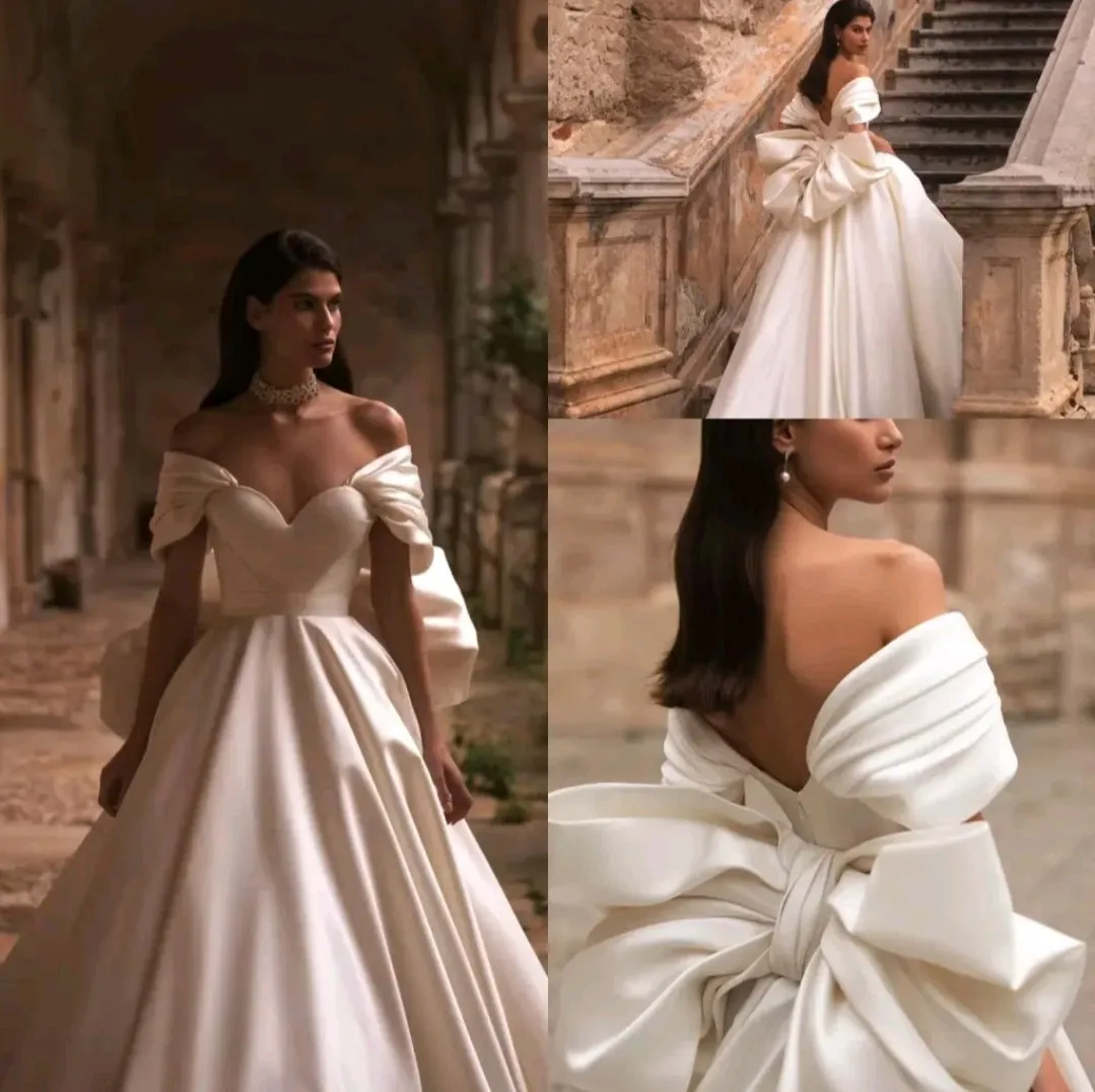 Ellegant off shoulder wedding dress. Satin bow back bridal gown.